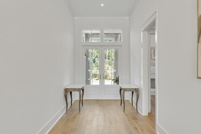 entryway with light hardwood / wood-style floors, crown molding, and french doors