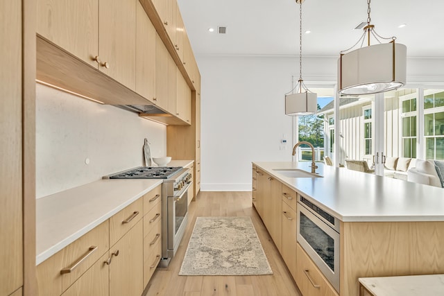 kitchen featuring light brown cabinetry, sink, light hardwood / wood-style flooring, and appliances with stainless steel finishes