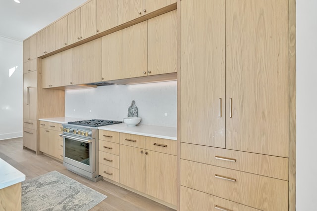 kitchen featuring light brown cabinets, light wood-type flooring, and stainless steel stove