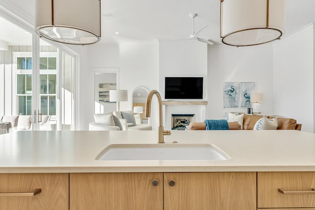 kitchen featuring sink, ceiling fan with notable chandelier, and light brown cabinets