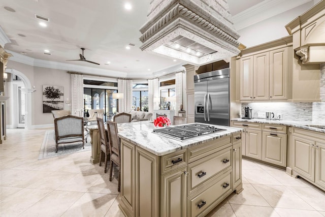 3400 Ravenwood Ln, Miramar Beach, FL 32550 - kitchen featuring stainless steel appliances, cream cabinetry, ornate columns, ceiling fan, and light tile patterned flooring