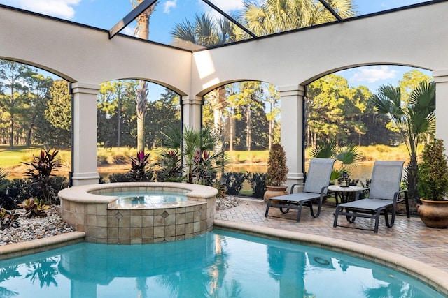 view of swimming pool featuring an in ground hot tub, a patio, and glass enclosure