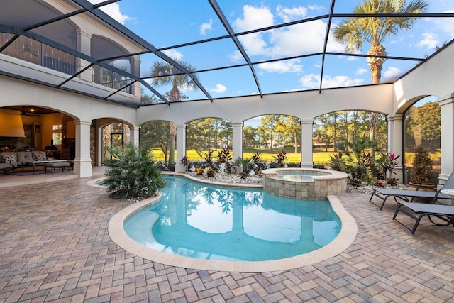 view of pool featuring a lanai, a patio area, and an in ground hot tub