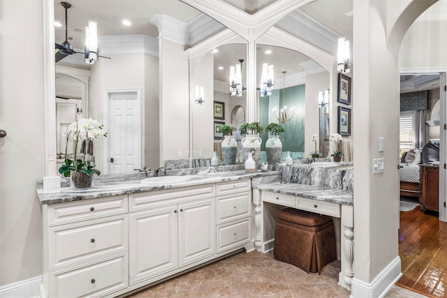 bathroom with vanity, ornamental molding, a notable chandelier, and hardwood / wood-style flooring