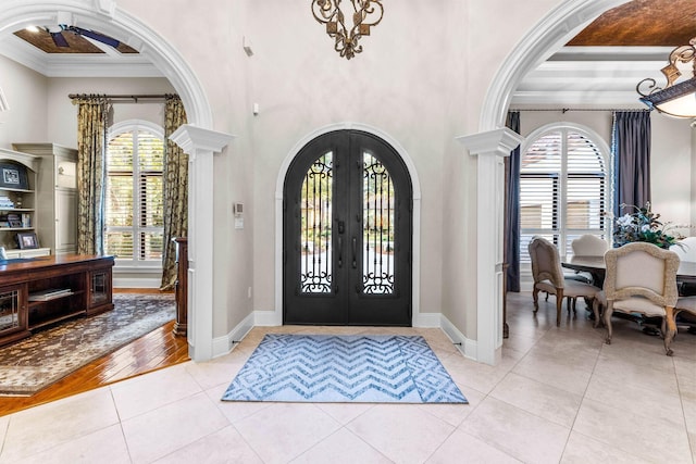3400 Ravenwood Ln, Miramar Beach, FL 32550 - entrance foyer with arched walkways, french doors, a high ceiling, crown molding, and light tile patterned floors