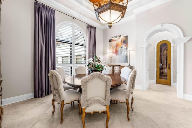 tiled dining room featuring decorative columns and ornamental molding