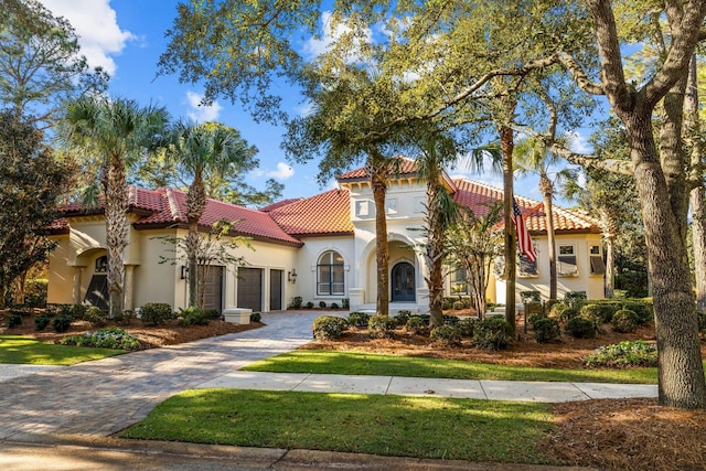 3400 Ravenwood Ln, Miramar Beach, FL 32550 - mediterranean / spanish home featuring an attached garage, a tile roof, stucco siding, and decorative driveway