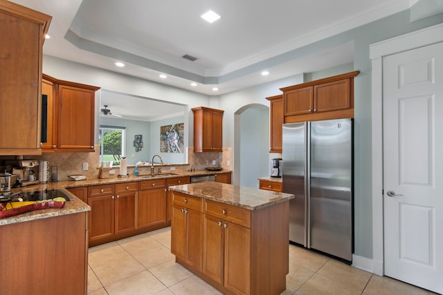 kitchen with appliances with stainless steel finishes, tasteful backsplash, a kitchen island, and sink