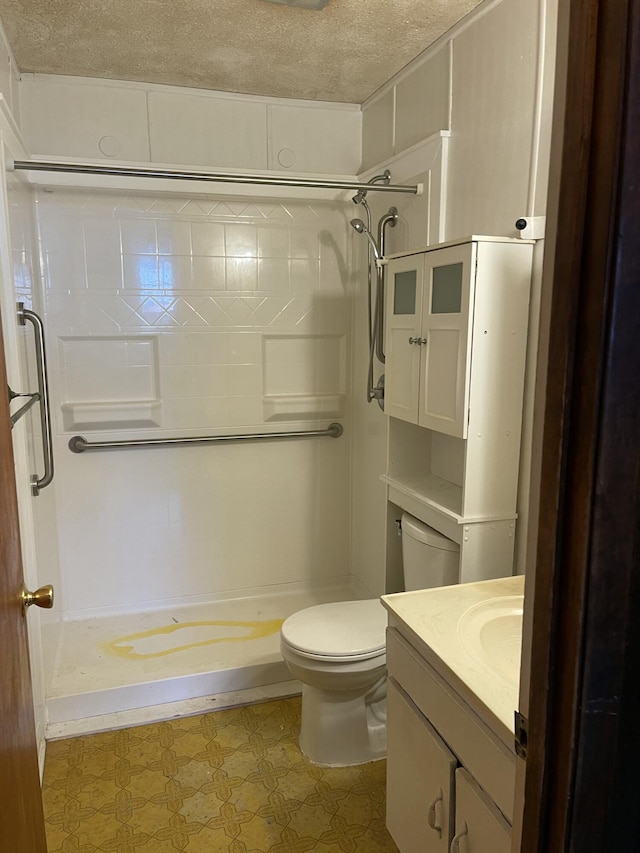 bathroom with toilet, vanity, a textured ceiling, and walk in shower