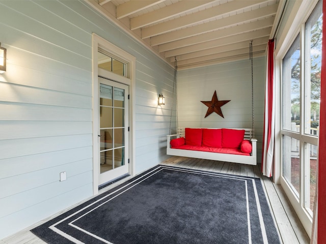 unfurnished sunroom featuring beam ceiling