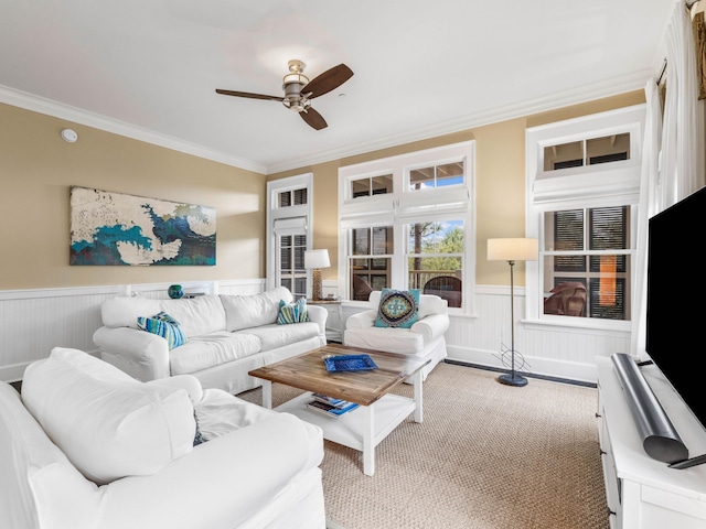 carpeted living room with ceiling fan and ornamental molding