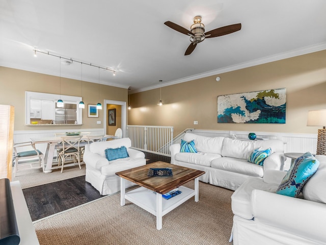 living room with dark wood-type flooring, track lighting, ceiling fan, and ornamental molding