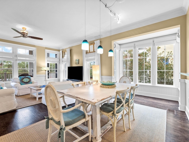 dining room featuring ceiling fan, dark wood-type flooring, track lighting, and ornamental molding