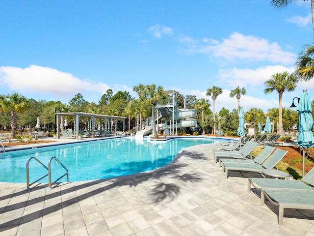 view of swimming pool with a patio area and a water slide