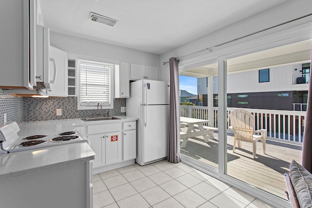 kitchen with white cabinets, white appliances, sink, and a wealth of natural light