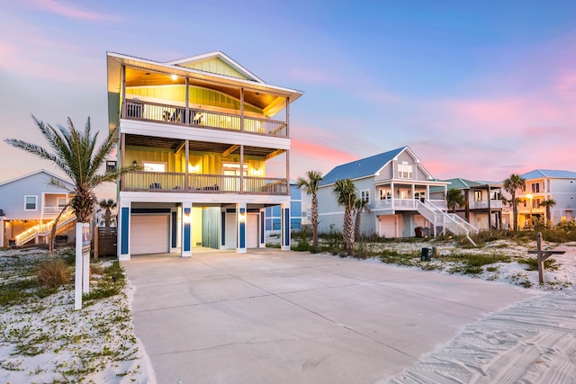 coastal home featuring a balcony and a garage