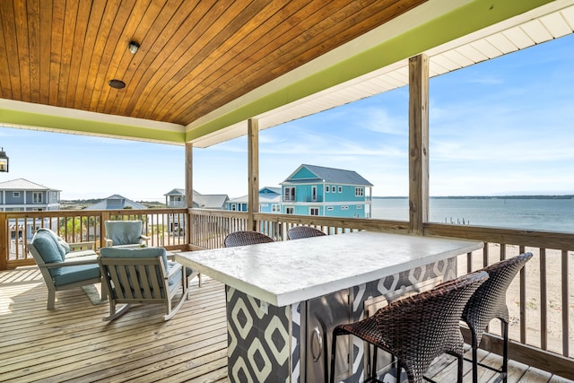 wooden terrace with an outdoor bar and a water view