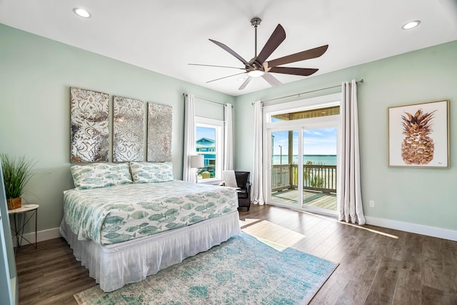 bedroom featuring ceiling fan, a water view, dark hardwood / wood-style floors, and access to outside