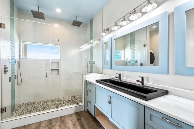 bathroom with walk in shower, vanity, and hardwood / wood-style flooring