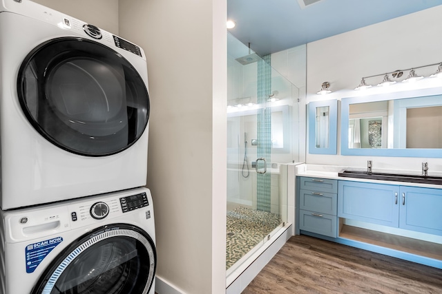 clothes washing area with stacked washing maching and dryer and dark hardwood / wood-style flooring