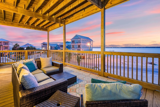 deck at dusk with a water view and outdoor lounge area