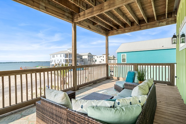 wooden terrace featuring a water view and an outdoor living space