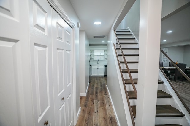 stairway with wood-type flooring and sink