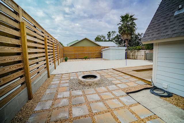 view of patio / terrace featuring a shed and a fire pit