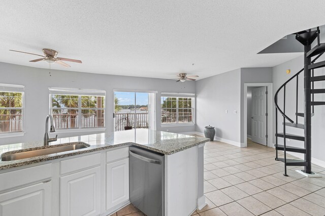 kitchen with dishwasher, white cabinets, sink, light stone countertops, and a textured ceiling