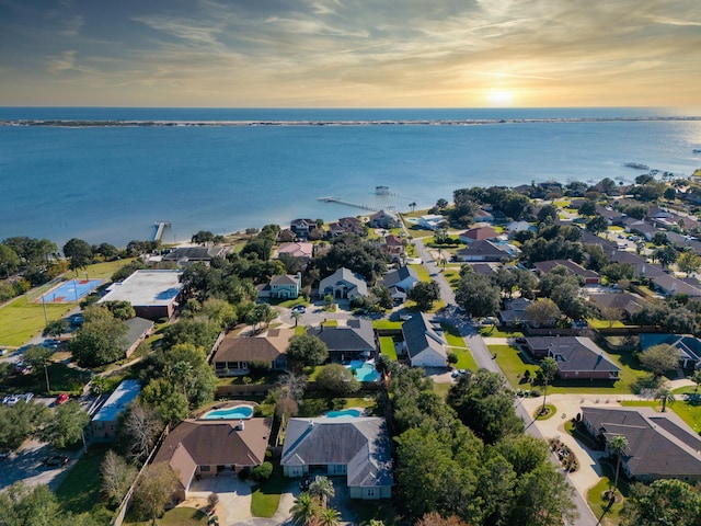 aerial view at dusk featuring a water view