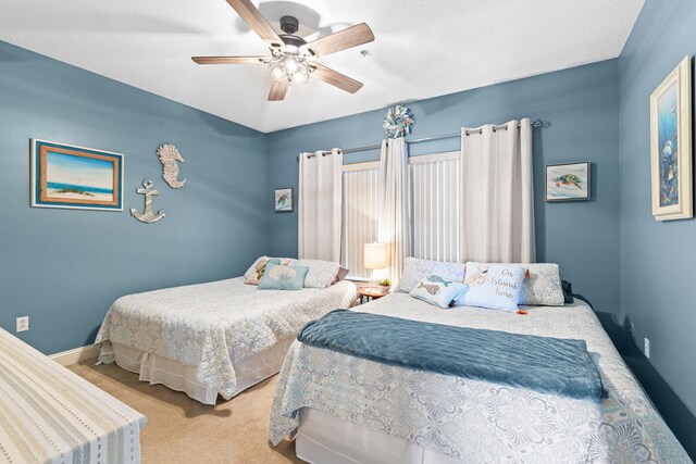 bedroom featuring a textured ceiling, ceiling fan, and light carpet