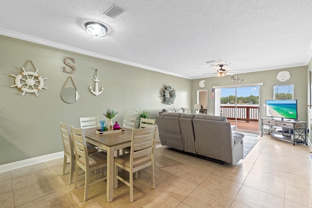 dining room featuring ceiling fan, light tile patterned flooring, ornamental molding, and a textured ceiling