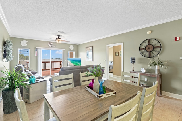 tiled dining area featuring crown molding, ceiling fan, and a textured ceiling