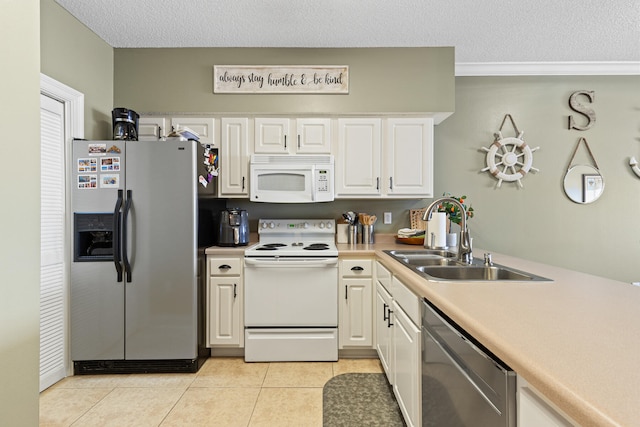 kitchen featuring white cabinets, appliances with stainless steel finishes, light tile patterned floors, and sink