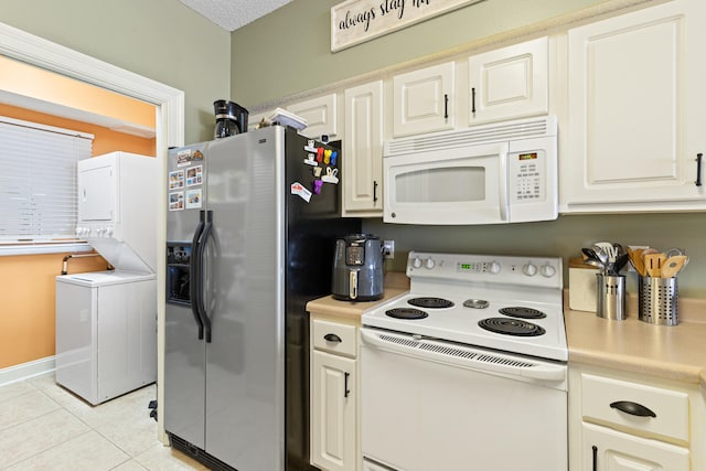 kitchen with stacked washer and clothes dryer, light tile patterned floors, and white appliances