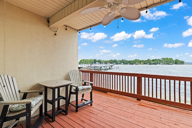 wooden terrace featuring ceiling fan and a water view