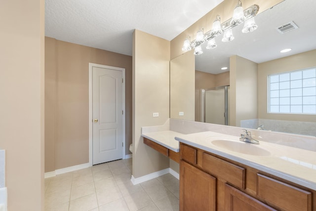 bathroom with tile patterned floors, walk in shower, vanity, a textured ceiling, and toilet