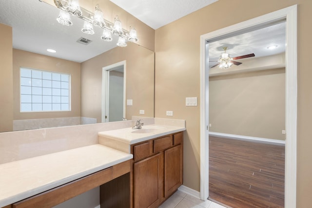 bathroom featuring hardwood / wood-style floors, vanity, ceiling fan, and a textured ceiling