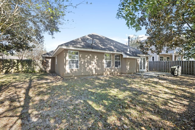 back of property featuring a yard and a patio