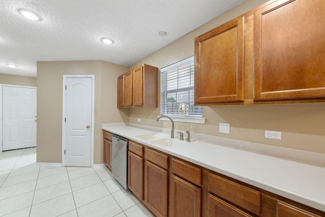 kitchen with sink, light tile patterned floors, stainless steel dishwasher, and a textured ceiling