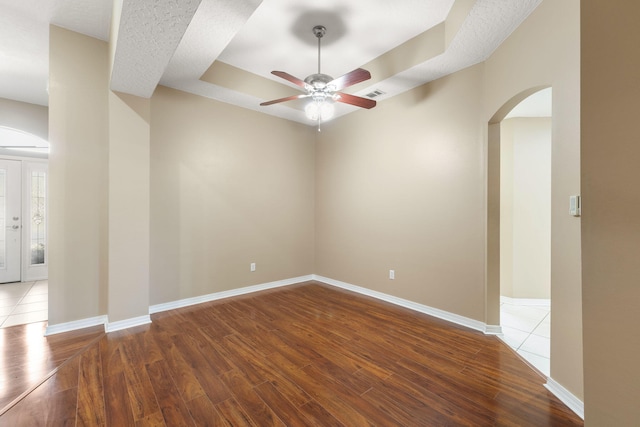 empty room featuring ceiling fan, a textured ceiling, and hardwood / wood-style flooring