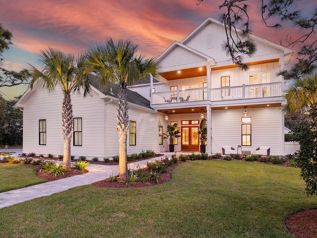 view of front facade with a lawn and a balcony