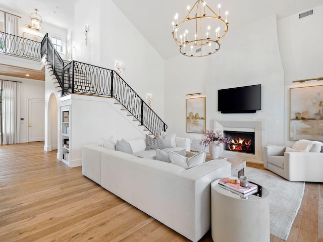 living room featuring high vaulted ceiling and light wood-type flooring