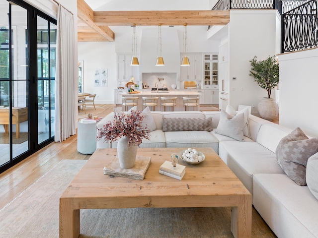 living room featuring beamed ceiling and light hardwood / wood-style floors