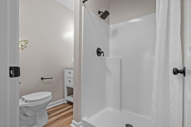 bathroom featuring toilet, hardwood / wood-style floors, and a shower with shower curtain