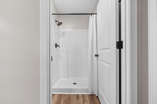 bathroom with curtained shower and hardwood / wood-style floors