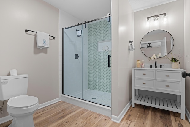 bathroom featuring vanity, wood-type flooring, an enclosed shower, and toilet