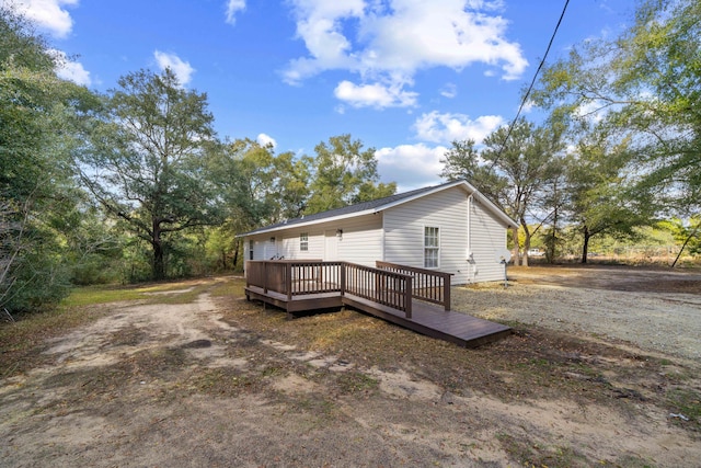 rear view of house featuring a wooden deck