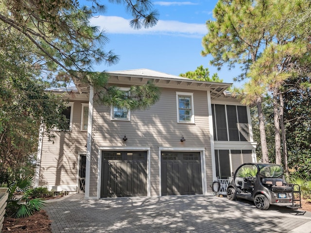 view of front facade featuring a sunroom and a garage