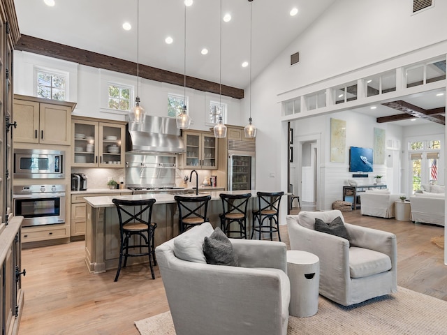 living room featuring beam ceiling, light hardwood / wood-style floors, high vaulted ceiling, and plenty of natural light